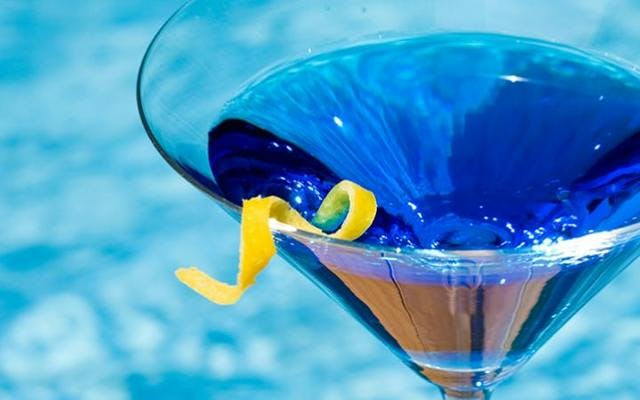 Blue hued gin cocktail with lemon zest