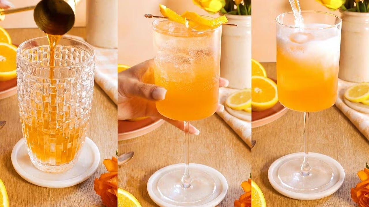 Orange spritz cocktail in a square wine glass with orange garnish