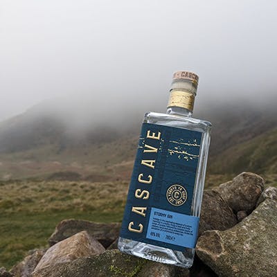 bottle of cascave gin on a foggy mountain top