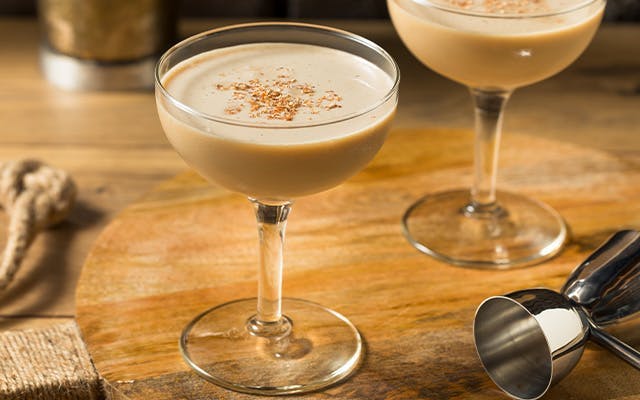 Praline Alexander cocktail in a coupe glass and topped with Biscoff crumbs