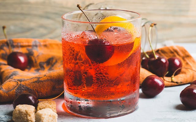 Cherry Negroni cocktail in a Rocks glass with cherries
