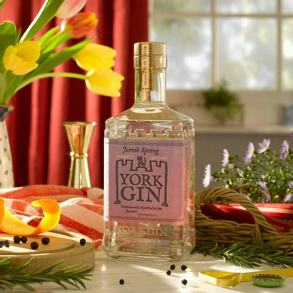 A bottle of York Gin's Jorvik Spring edition gin surrounded by colourful flowers