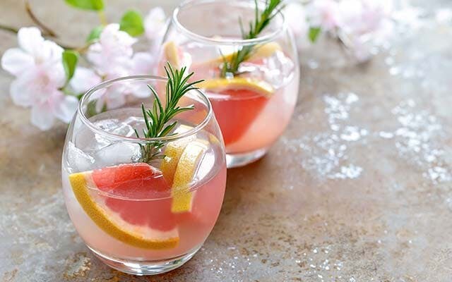 Grapefruit juice is a refreshing and pretty mixer for gin, especially with a sprig of rosemary to garnish