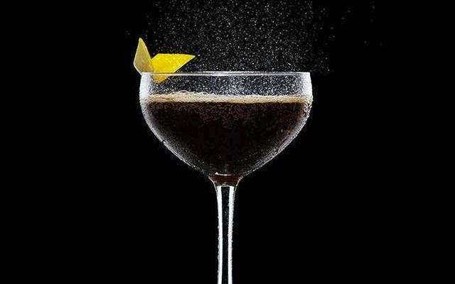 Gin Cola in martini glass fizzing with lemon zest twist garnish