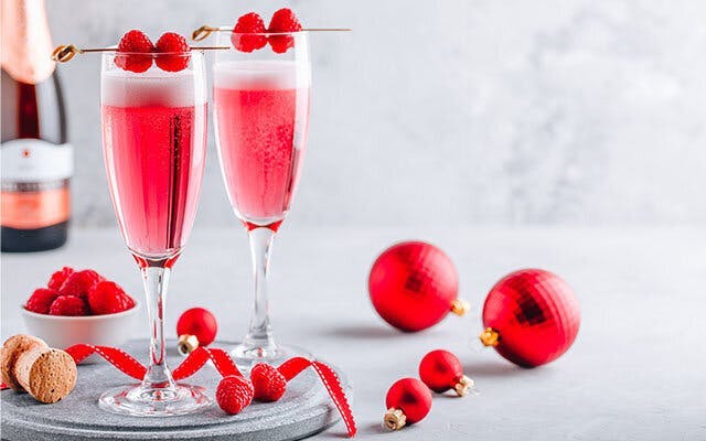A raspberry and champagne pink cocktail with raspberry garnish