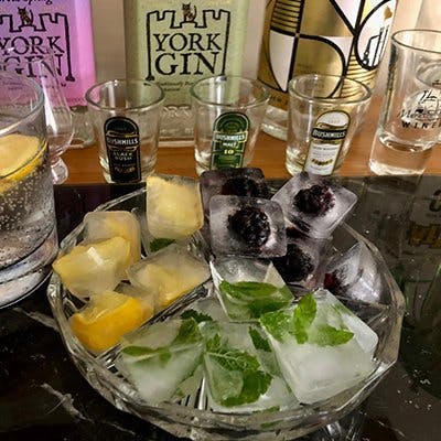 A bowl of homemade ice with a range of different fruits and herbs frozen in, including lemon, blackberries and mint