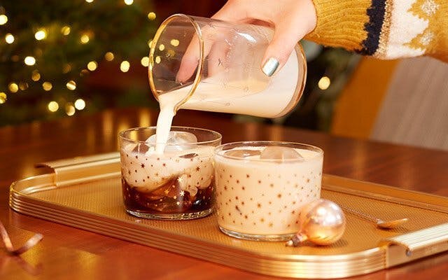 Two creamy caramel cocktails in a Christmas table setting