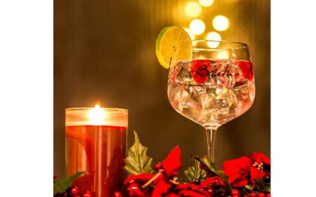 Batch gin perfect serve with raspberries and lime, scented christmas candel