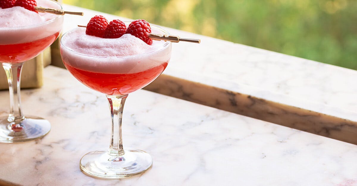 Meet the Clover Club: a raspberry martini topped with foam and fresh raspberries!