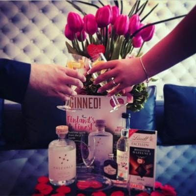 Roses in a vase with ginned magazine and gin bottle with chocolate cheersing on valentines day