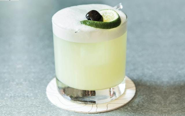 Green eyed gin cocktail with lime and cherry