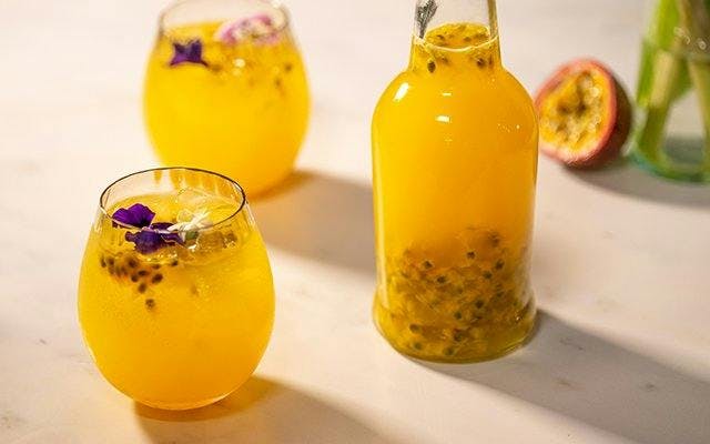 Passion fruit gin with tumbler of gin and tonic.