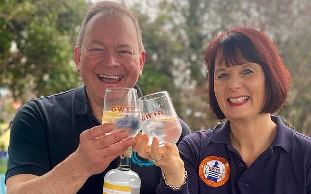 A man and a woman from Gower Gin Company cheers two glasses of G&T