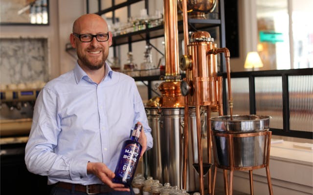 Marylebone gin distillery tour owner next to the copper still