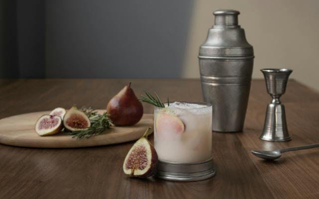 Cocktail with cocktail shaker and fig garnish
