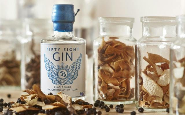 58 Gin surrounded by botanicals