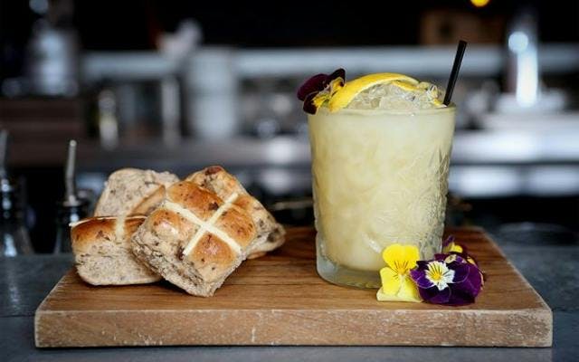 Hot cross buns and easter gin cocktail with edible flowers