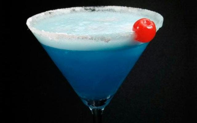 Blue lady gin cocktail with glacier cherry