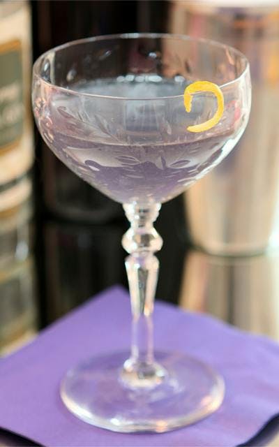 Violet liqueur creme blue moon gin cocktail with lemon zest