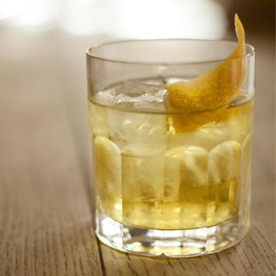 White gin negroni in tumbler with twist of lemon garnish
